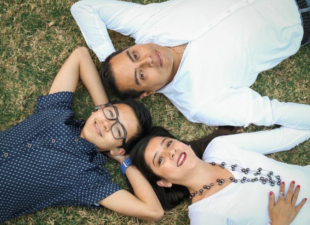 The Art of Drawing Readers In: Your attractive post title goes here A joyful family lying on grass enjoying a sunny day together.