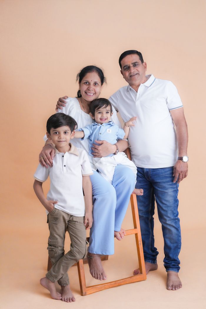 services-01 A joyful family portrait featuring parents with their two children in a studio setting.